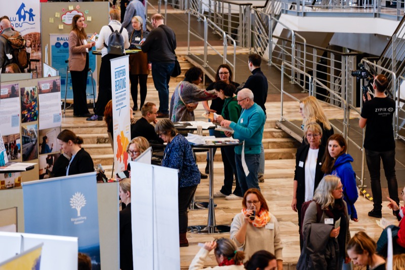 Ausstellungsbereich mit Besuchern und Ständen